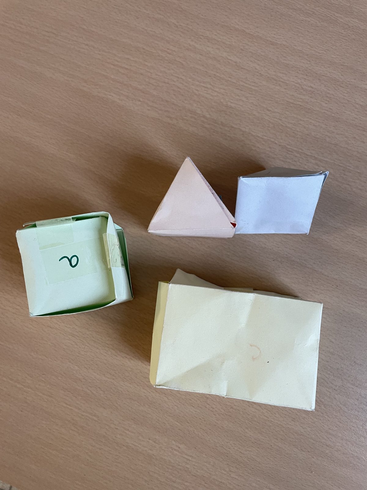 Patrons de solides en papier (cube, pyramide, prisme) utilisés pour manipuler les formes géométriques en classe